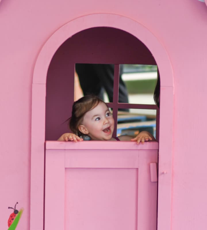 Little girl playing in a playhouse
