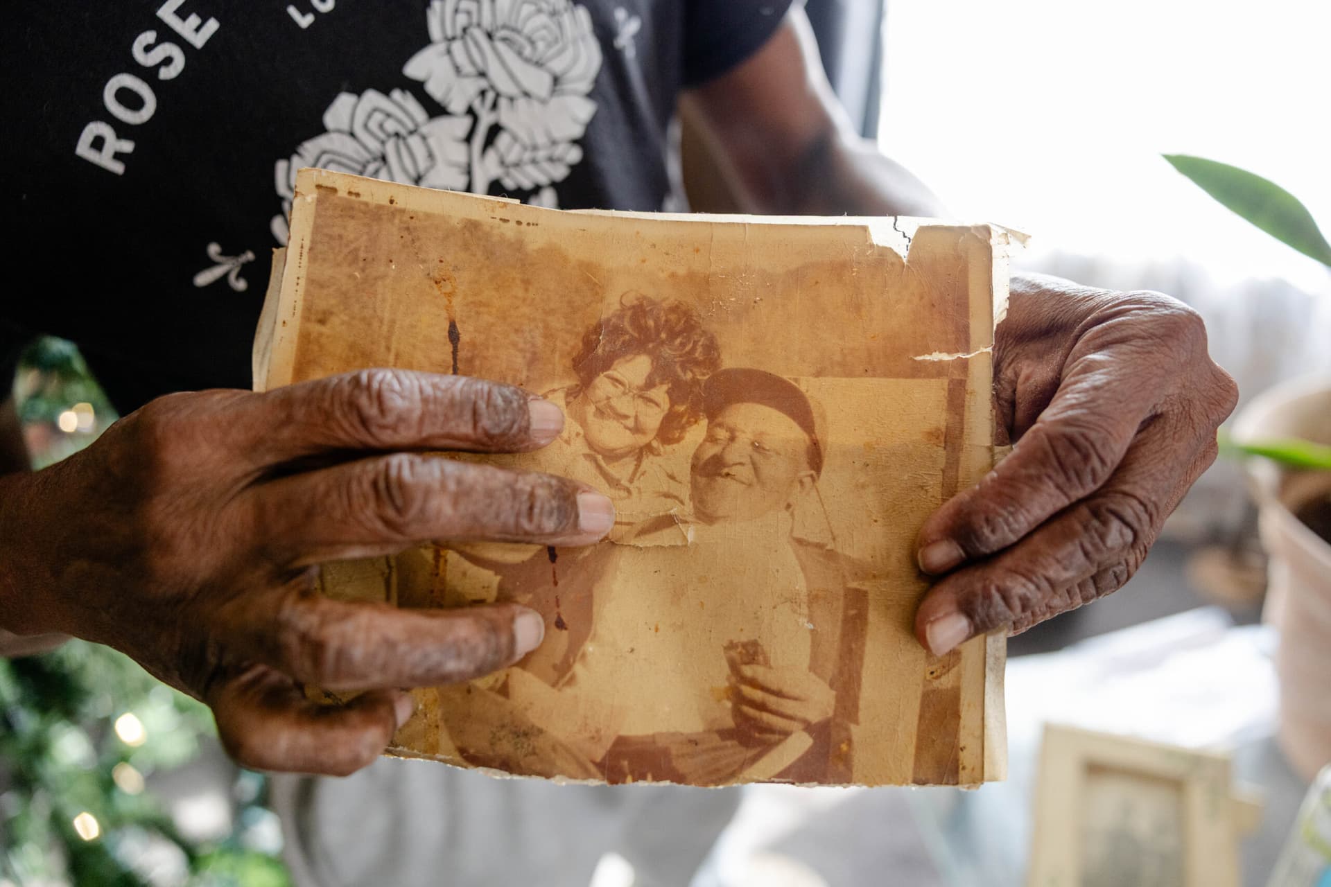 Two hands holding an aged photograph.