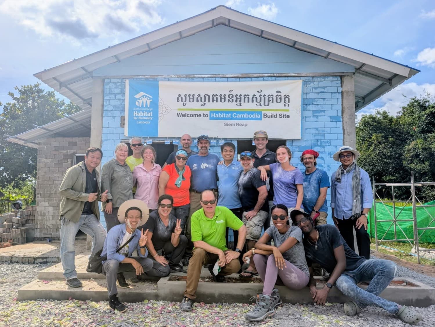 Volunteers in Cambodia posing in front of a completed home.