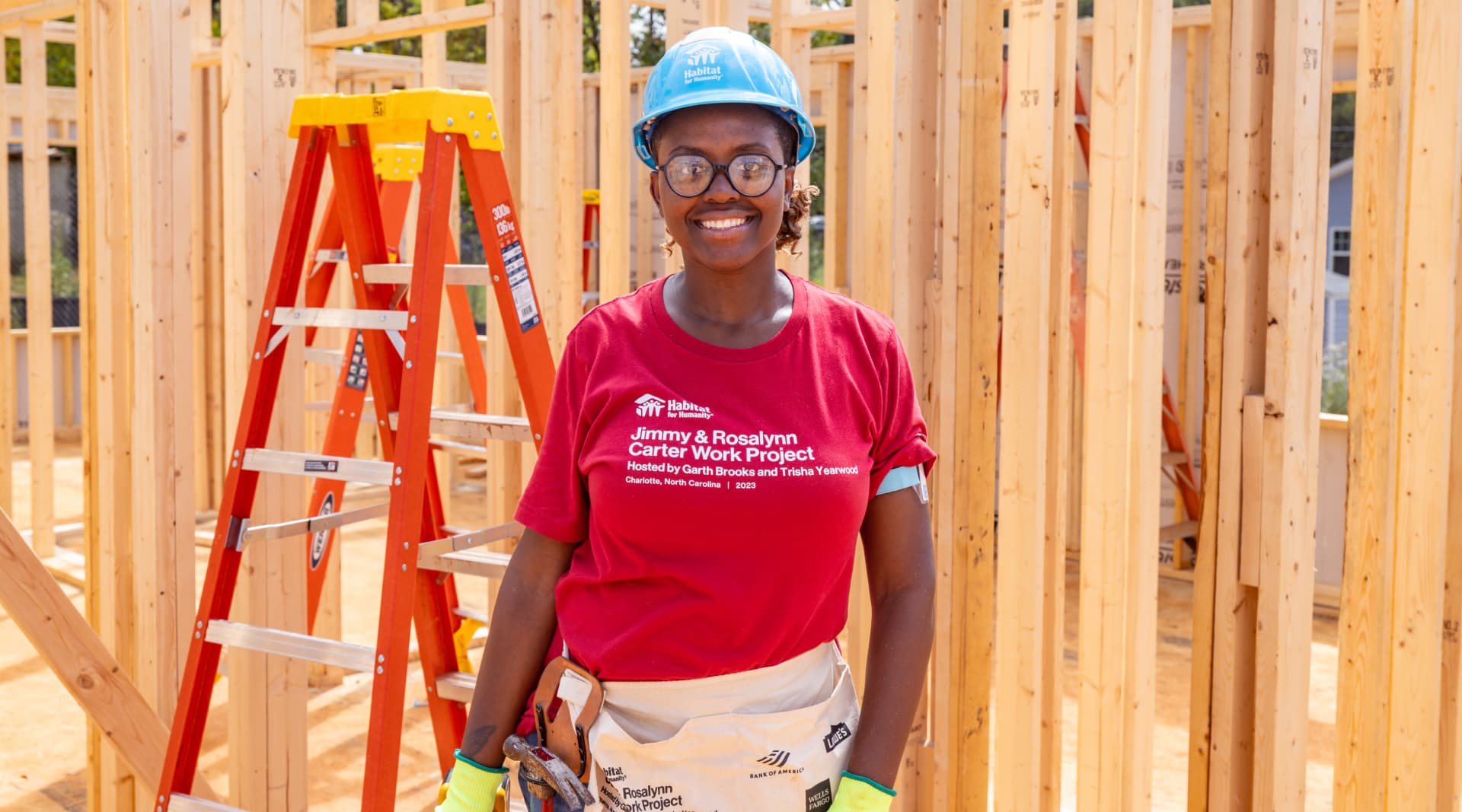 Habitat for humanity volunteer inside an unbuilt home with just wooden frames