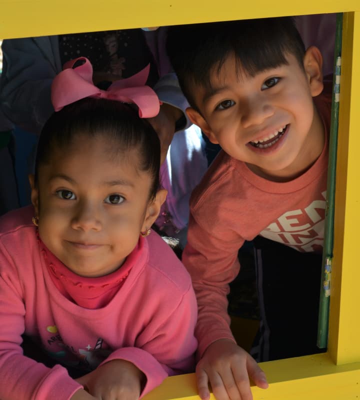 children playing inside of a playhouse