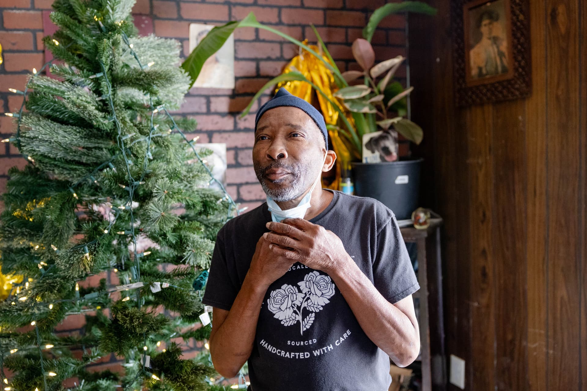 A man stands in front of a Christmas tree.