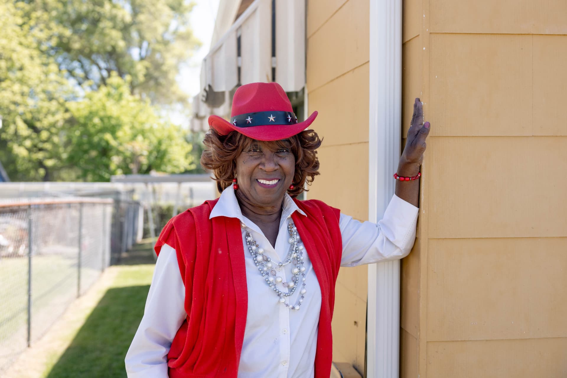 Tarba smiling and standing outside her home