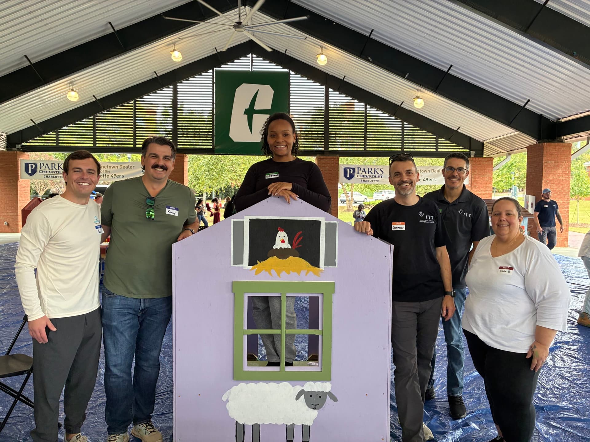 Volunteers posing with farm themed playhouse