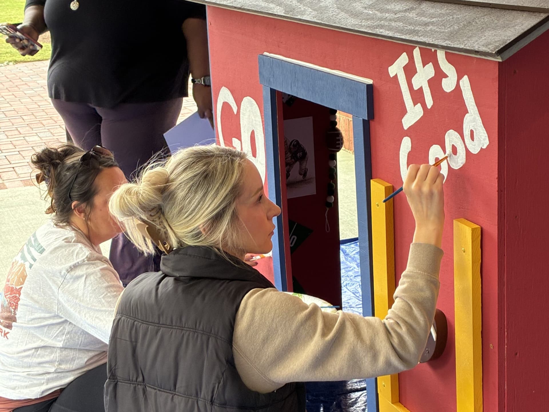Volunteer painting playhouse