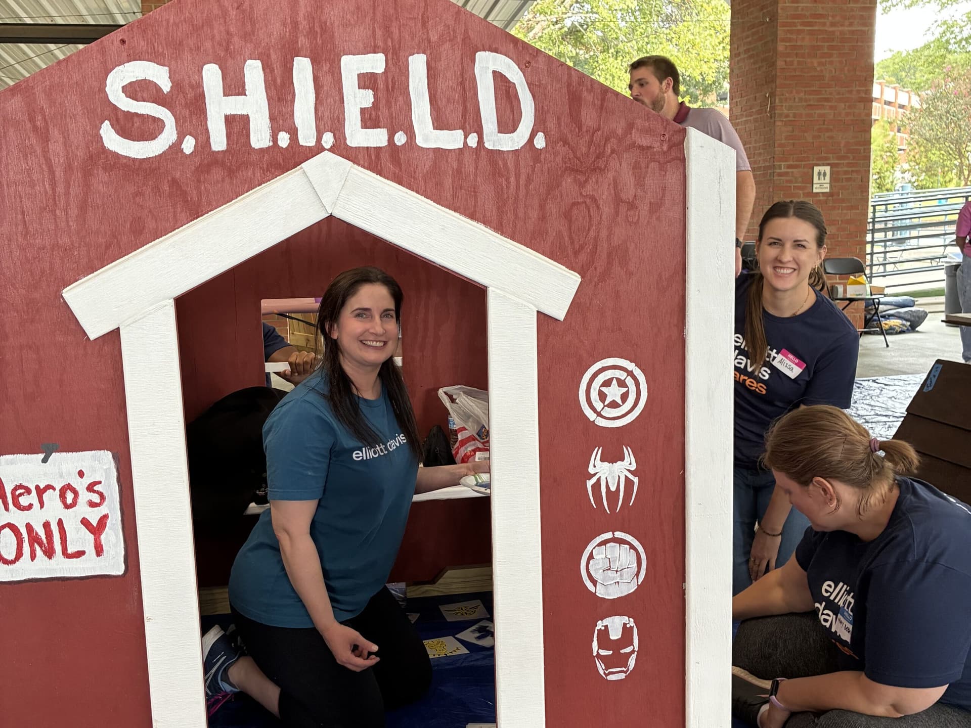 Volunteers painting Marvel themed Playhouse