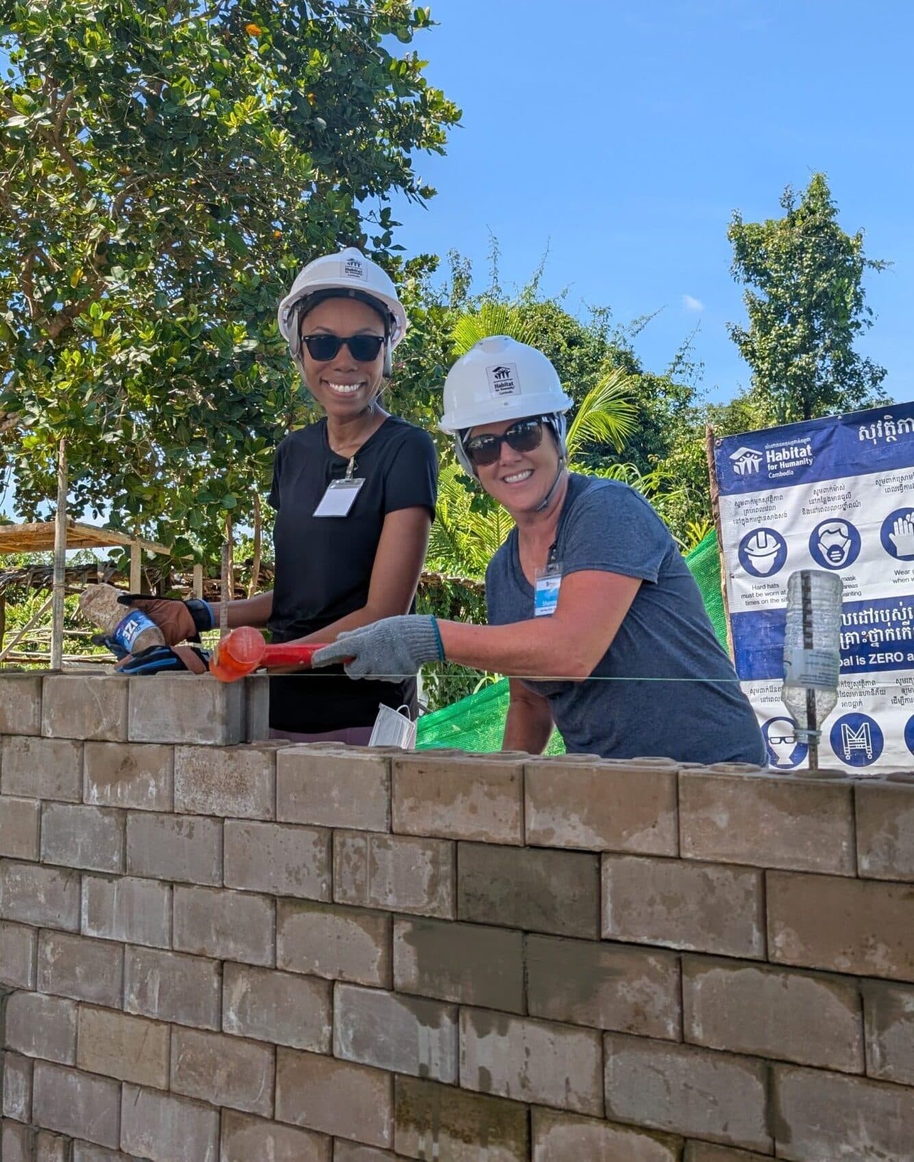 Volunteers build a wall of bricks.