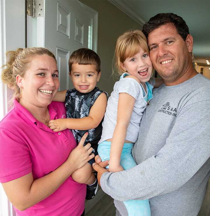 Family of four at their Habitat house front door
